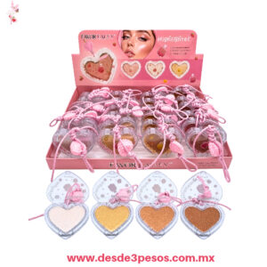 Caja con 24 piezas de Iluminador Facial 4 tonos Favor Beauty. Diseñado en  estuche transparente en forma de corazón 7 x 6 cm. ITEM6849